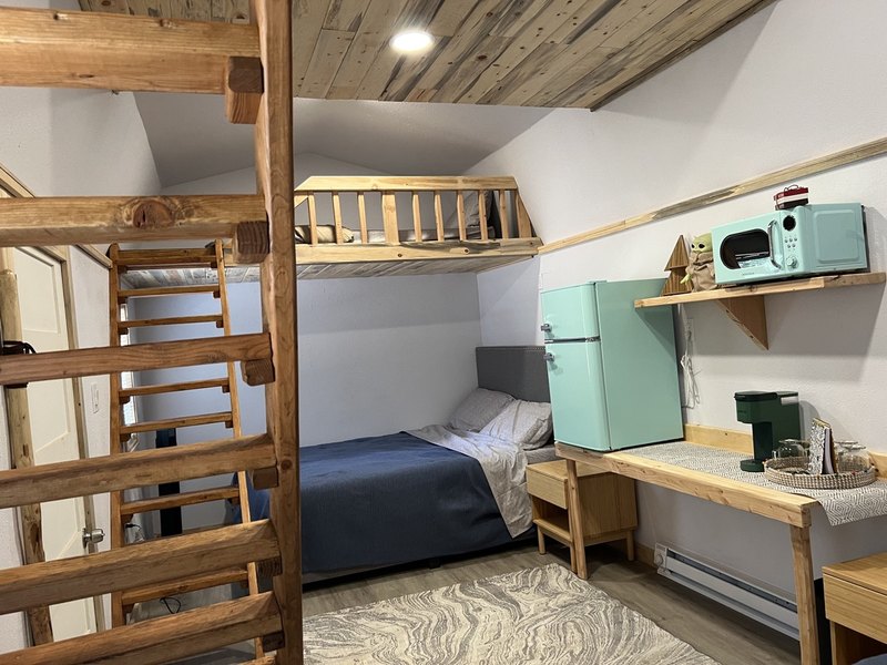 Inside The Moose cabin at Round Mountain Retreat — a bright studio cabin with wood detailing, furnished for six guests.